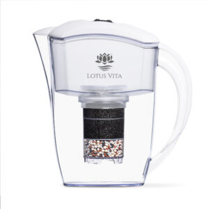 Seitliche Ansicht einer durchsichtigen Wasserfilterkanne mit weißem Deckel und dem Lotus Vita Logo, die den mehrschichtigen Aufbau der Filterkartusche zeigt.